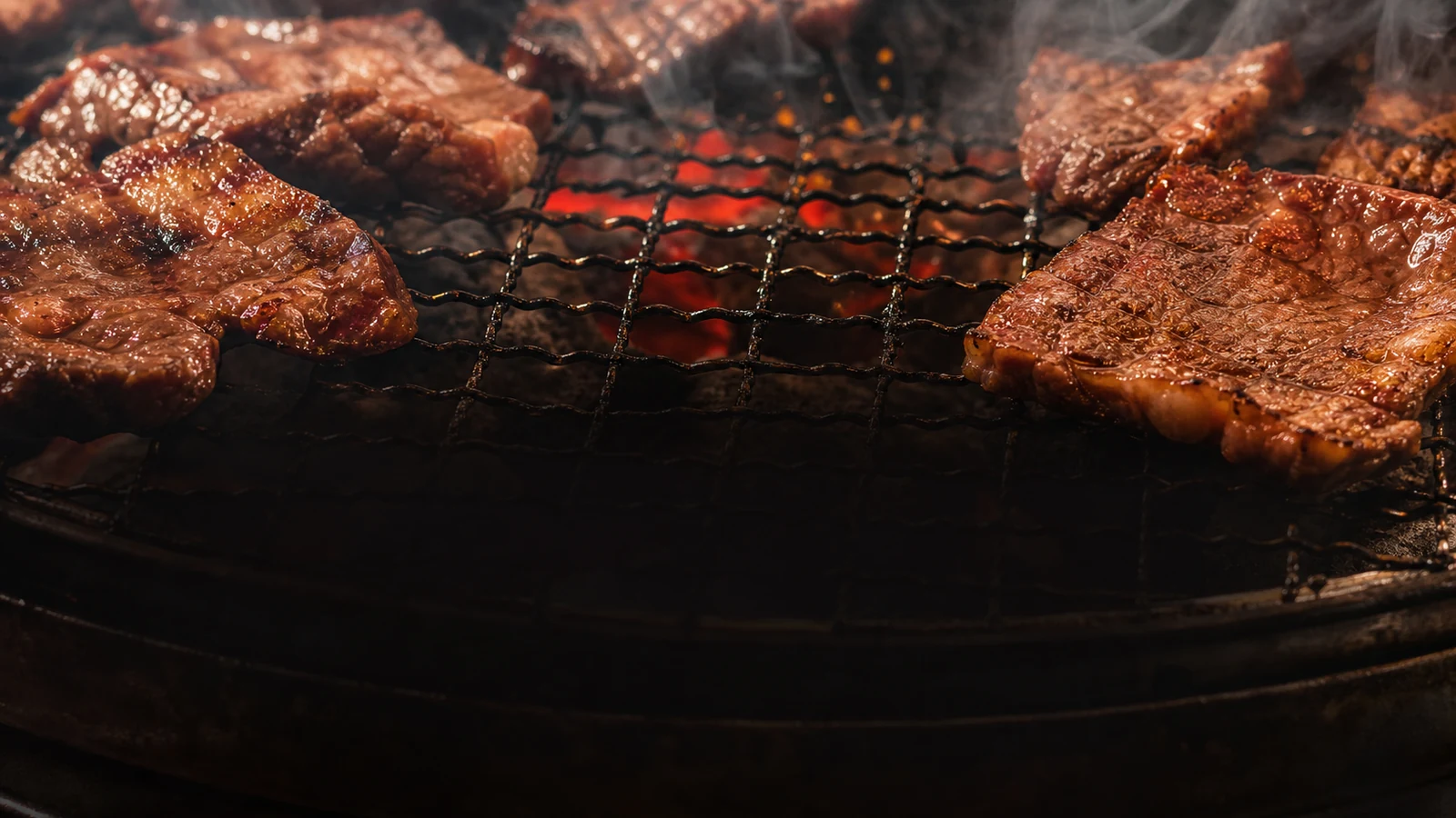 炭火の網の上で焼ける肉